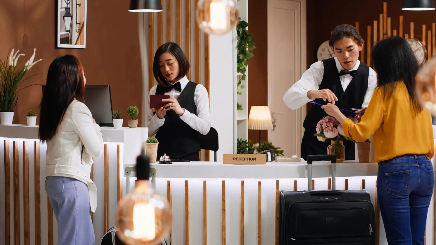 Hospitality staff assisting guests at a hotel reception